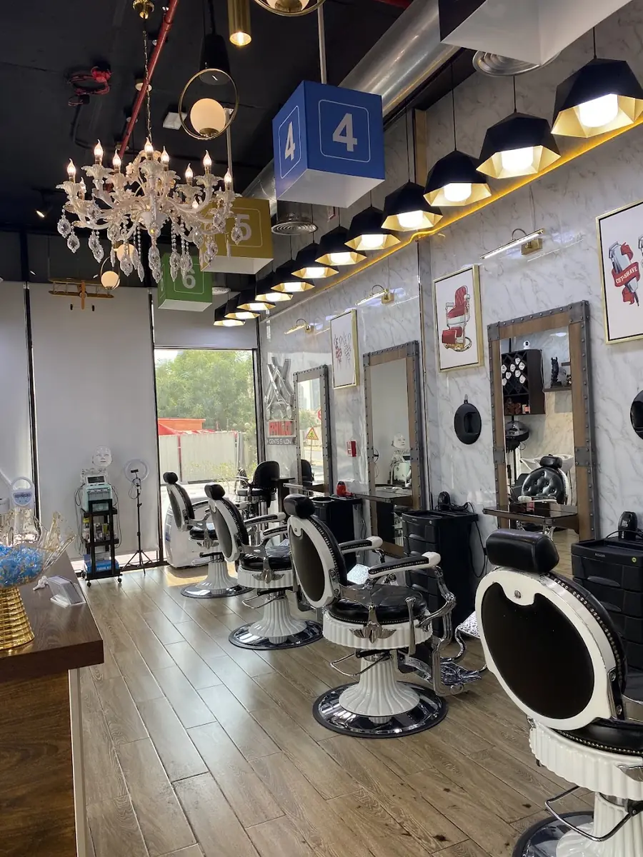 The cutting floor with barber chairs, mirrors and a crystal chandelier